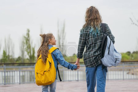 Foto de Una adolescente que va a la escuela con su hermano pequeño. - Imagen libre de derechos