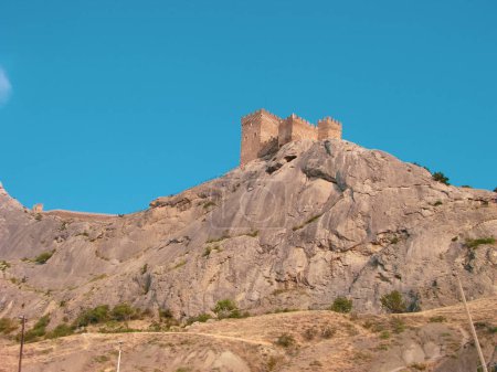 Foto de Una fortaleza medieval sobre una roca de piedra sobre el fondo de un cielo azul claro. - Imagen libre de derechos
