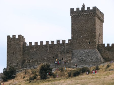 Foto de Una fortaleza medieval sobre una roca de piedra sobre el fondo de un cielo azul claro. - Imagen libre de derechos