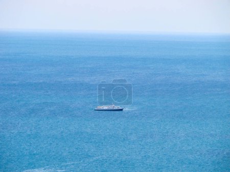 Téléchargez les photos : Un navire au milieu d'une eau bleue calme et un ciel clair à l'horizon. Yacht de croisière vue de dessus. - en image libre de droit