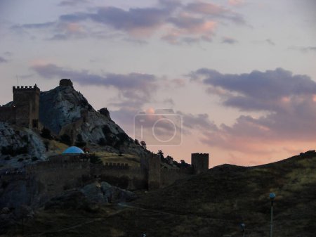 Foto de Una fortaleza medieval sobre una roca de piedra sobre el fondo de un brillante cielo nocturno. - Imagen libre de derechos