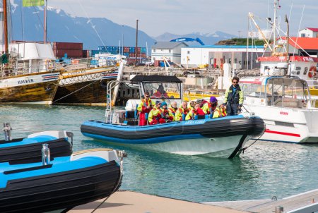 Photo for Husavik Iceland - July 15. 2021: Whale watching safari boat with tourists entering the port after a trip - Royalty Free Image