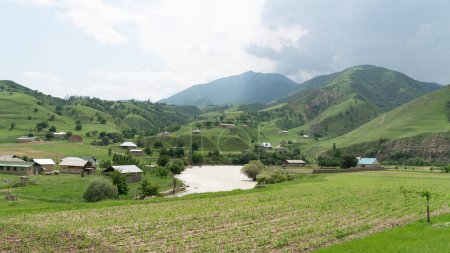Foto de Kirguistán naturaleza verde paisaje con vastas montañas. Kirguistán es un país sin litoral situado en el centro de Asia, conocido por su terreno accidentado y montañoso y sus verdes praderas.. - Imagen libre de derechos