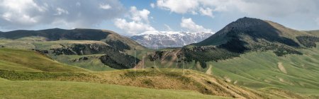 Foto de Kirguistán naturaleza verde paisaje con vastas montañas. Kirguistán es un país sin litoral situado en el centro de Asia, conocido por su terreno accidentado y montañoso y sus verdes praderas.. - Imagen libre de derechos