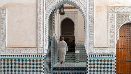 Foto de Meknes, Marruecos - Septiembre 2022: Hombre marroquí caminando dentro del mausoleo de Moulay Ismail, lugar de descanso final de Moulay Ismail, un poderoso sultán que gobernó Marruecos durante el siglo XVII. - Imagen libre de derechos