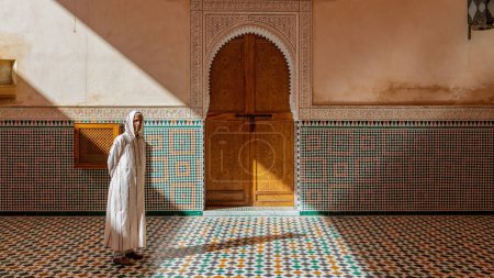 Foto de Meknes, Marruecos - Septiembre 2022: Hombre marroquí caminando dentro del mausoleo de Moulay Ismail, lugar de descanso final de Moulay Ismail, un poderoso sultán que gobernó Marruecos durante el siglo XVII. - Imagen libre de derechos