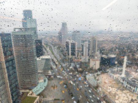 Photo for Istanbul, Turkey -17 March 2023: Levent financial district with skyscrapers and traffic on a rainy day as seen behind a wet window with raindrops - Royalty Free Image
