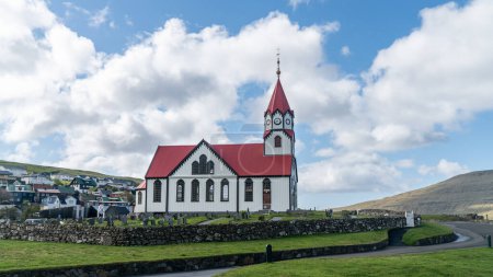 Téléchargez les photos : Eglise du village de Sandavagur dans les îles Féroé, un lieu de tradition, où les baptêmes, les mariages et les services du dimanche rassemblent les villageois - en image libre de droit