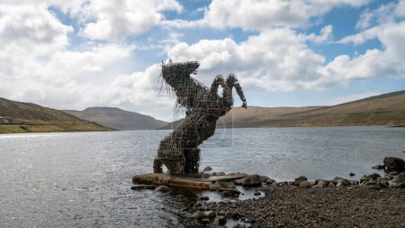 Téléchargez les photos : Torshavn, Îles Féroé - 14 mai 2019 : Statue de Nix Nykur au bord du lac Tjornin. Nix Nykur est un cheval d'eau mythique dans le folklore islandais, parcourt rivières et lacs attirant les voyageurs sans méfiance - en image libre de droit