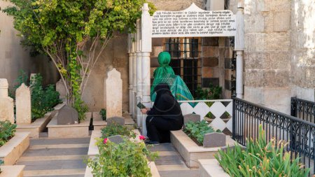 Photo for Gaziantep, Turkey - 16.10.2022: Religious woman praying in the courtyard of Seyh Fethullah Mosque by Seyh Fethullah's tomb - Royalty Free Image