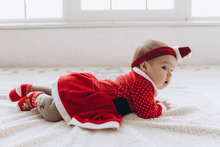 Photo for Portrait of a funny little baby girl in Christmas clothes - Royalty Free Image