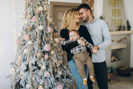 Photo for Portrait of happy family of father mother and little curly son celebrating Christmas together at home. New Year`s Eve concept. - Royalty Free Image