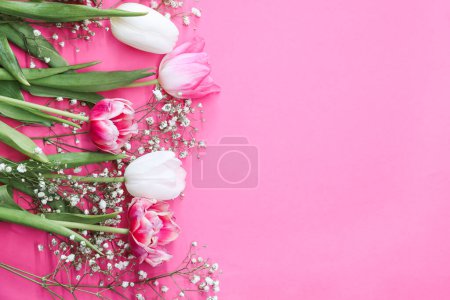 Photo for Pink tulips and white gypsophila flowers bouquet on a pink background. Mothers Day, birthday celebration concept. Copy space for text. Mockup - Royalty Free Image