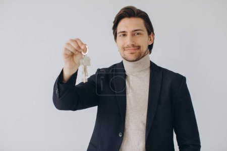 Téléchargez les photos : Portrait d'agent immobilier professionnel joyeux tenant presse-papiers et montrant les clés dans la main, foyer sélectif. - en image libre de droit