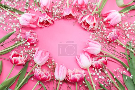 Téléchargez les photos : Des tulipes roses et un bouquet blanc de fleurs de gypsophile autour d'un fond rose. Fête des mères, concept de fête d'anniversaire. Espace de copie pour le texte. Maquette - en image libre de droit