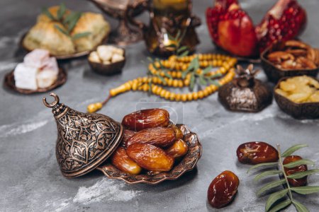 Foto de Mesa de Ramadán, dátiles en el fondo de platos tradicionales con otras comidas, frutas secas, granate fresco, té. - Imagen libre de derechos