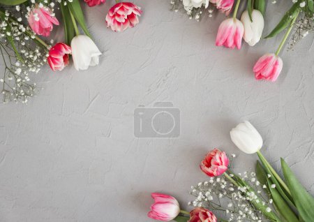 Téléchargez les photos : Bouquet de fleurs de tulipes roses et gypsophiles blanches sur un élégant fond de pierre grise. Fête des Mères, concept de fête d'anniversaire. Espace de copie pour le texte - en image libre de droit