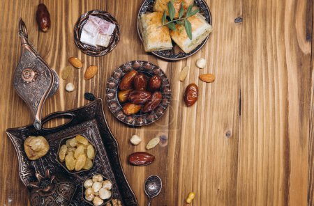 Photo for Dried dates and tea on a wooden table. Arabic traditional dishes, pots and dates fruits. Ramadan Kareem, Eid mubarak concept. Top view. Flat lay. Copy space - Royalty Free Image