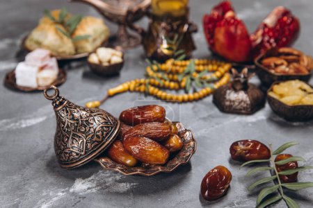Photo for Ramadan table, dates on the background of traditional dishes with other meal, dried fruits, fresh garnet, tea. - Royalty Free Image