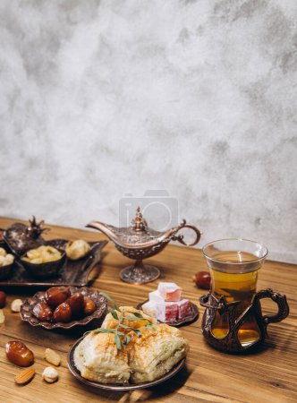 Foto de Fechas secas y té en una mesa de madera. Platos tradicionales árabes, macetas y dátiles de frutas. Ramadan Kareem, concepto de Eid mubarak. Copiar espacio - Imagen libre de derechos