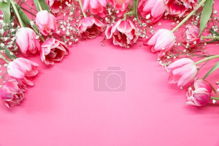 Téléchargez les photos : Bouquet de fleurs de tulipes roses et gypsophiles blanches sur fond rose. Fête des Mères, concept de fête d'anniversaire. Espace de copie pour le texte. Maquette - en image libre de droit