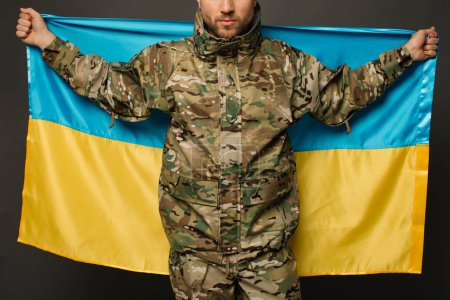 Téléchargez les photos : Portrait d'un militaire ukrainien courageux tenant le drapeau de l'Ukraine, concept de liberté - en image libre de droit