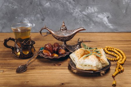 Foto de Concepto de Ramadán, taza de té, plato de dátiles dulces y baklava, espacio para copiar - Imagen libre de derechos