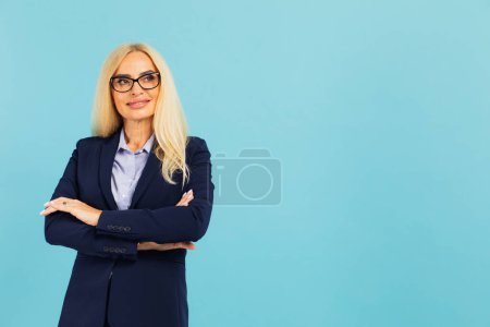 Foto de Retrato de una atractiva mujer de mediana edad sobre un fondo azul - Imagen libre de derechos
