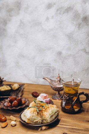 Téléchargez les photos : Dates séchées et thé sur une table en bois. Plats arabes traditionnels, pots et dattes de fruits. Ramadan Kareem, concept Eid Moubarak. Espace de copie - en image libre de droit