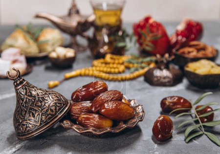 Photo for Ramadan table, dates on the background of traditional dishes with other meal, dried fruits, fresh garnet, tea. - Royalty Free Image