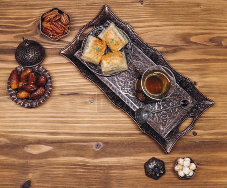 Photo for Ramadan table top view. Banner with traditional Arabic dishes, cup of tea and food sets - Royalty Free Image
