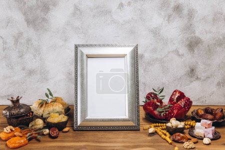 Foto de Composición para Ramadán. Marco de plata con espacio de copia o maqueta, cerca de la vajilla islámica tradicional con comida en mesa de madera. - Imagen libre de derechos