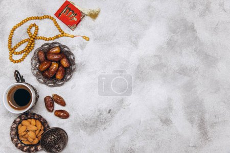 Téléchargez les photos : Table image vue du dessus de la décoration Ramadan Kareem, dates fruits, tasse de café et d'amande sur fond de pierre grise. Pose plate avec espace de copie. - en image libre de droit