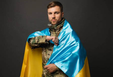 Téléchargez les photos : Portrait d'un militaire ukrainien courageux tenant le drapeau de l'Ukraine, concept de liberté - en image libre de droit