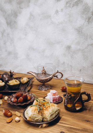 Photo for Dried dates and tea on a wooden table. Arabic traditional dishes, pots and dates fruits. Ramadan Kareem, Eid mubarak concept. Copy space - Royalty Free Image