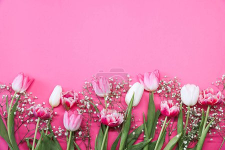 Foto de Tulipanes rosados y ramo de flores de gypsophila blanco sobre un fondo rosa. Día de las Madres, concepto de celebración de cumpleaños. Copia espacio para texto. Burla. - Imagen libre de derechos