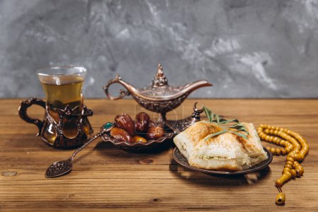 Foto de Concepto de Ramadán, taza de té, plato de dátiles dulces y baklava, espacio para copiar - Imagen libre de derechos