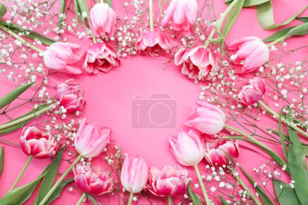 Photo for Pink tulips and a white bouquet of gypsophila flowers around a pink background. Mother's day, birthday celebration concept. Copy space for text. Mockup - Royalty Free Image