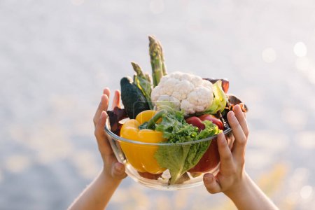 Téléchargez les photos : Mains féminines tenant une assiette de légumes frais - en image libre de droit