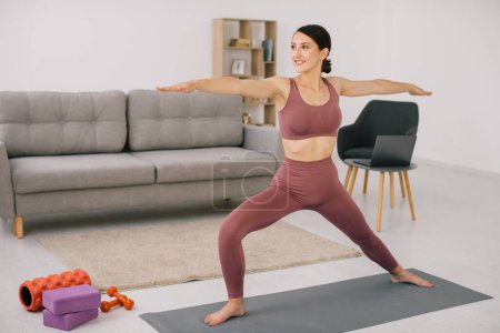 Photo for Attractive and healthy young woman doing exercises while resting at home - Royalty Free Image