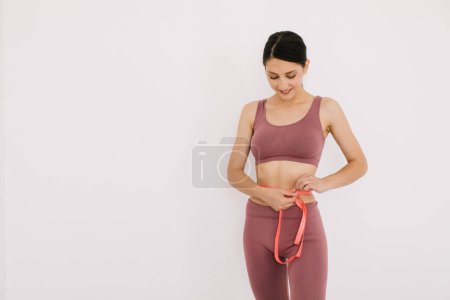 Téléchargez les photos : Femme mesure le souverain son ventre. Le concept de régime alimentaire et de perte de poids. - en image libre de droit