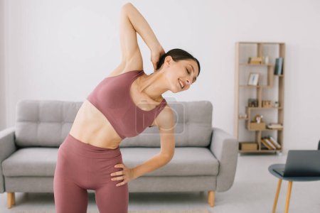 Photo for Attractive and healthy young woman doing exercises while resting at home - Royalty Free Image