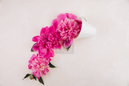 Foto de Diseño creativo hecho de café o taza de té con flores rosadas sobre fondo pastel - Imagen libre de derechos
