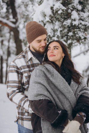 Photo for Portrait of a young happy and loving couple having fun in a snowy forest - Royalty Free Image