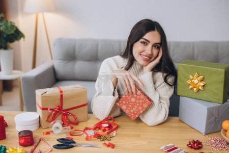 Foto de Hermosa mujer feliz está envolviendo y la celebración de regalos de Navidad en casa - Imagen libre de derechos