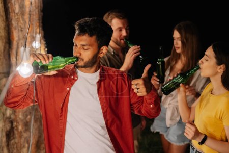 Téléchargez les photos : Indien buvant de la bière sans arrêt, buvant beaucoup de bière lors d'une fête avec des amis, accro à l'alcool - en image libre de droit