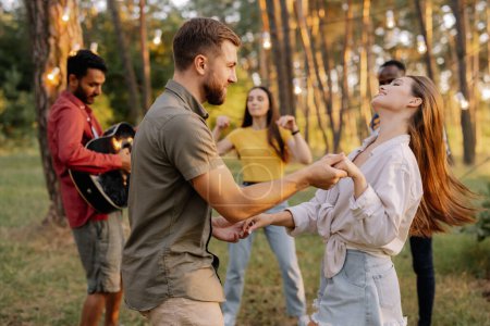Téléchargez les photos : Un beau couple dansant sur fond d'amis s'amusant - en image libre de droit