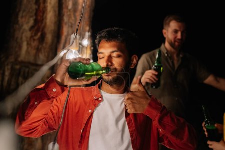 Foto de Hombre indio bebiendo cerveza sin parar, bebiendo mucha cerveza en una fiesta con amigos, adicto al alcohol - Imagen libre de derechos
