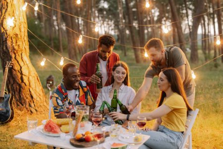 Téléchargez les photos : Groupe d'amis multiraciaux s'amuser à la fête, boire de la bière et porter un toast - en image libre de droit