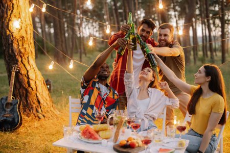 Téléchargez les photos : Groupe d'amis multiraciaux s'amuser à la fête, boire de la bière et porter un toast - en image libre de droit